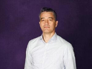 Dimitrius Oliveira, CEO global da Atento, está de camisa branca num fundo preto