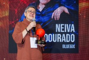 Neiva Douado, premiada como profissional do ano pelo Prêmio Smart Customer, da Garrido Marketing, recebe um troféu vermelho