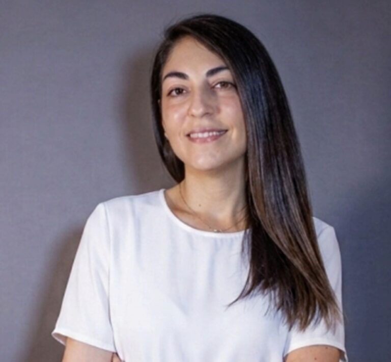 Daniela Guillen, nova diretora de CX da Gol, tem cabelos longos, castanho escuro e está de camiseta branca